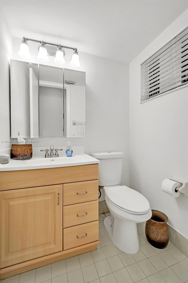 bathroom featuring tile patterned flooring, vanity, and toilet