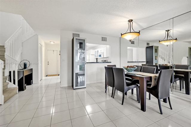 dining area with light tile patterned floors and a textured ceiling