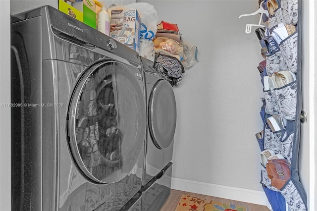 washroom with washing machine and dryer and hardwood / wood-style floors