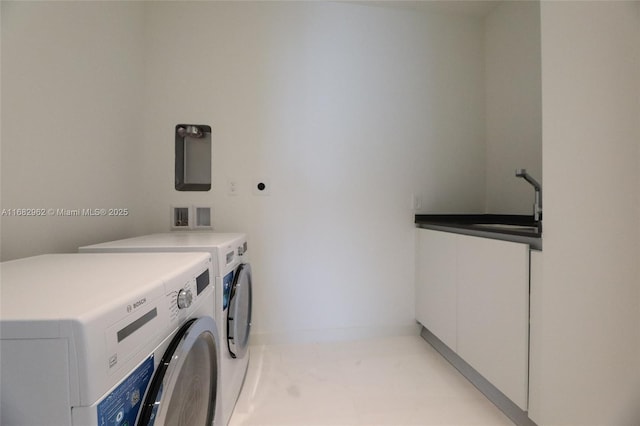 laundry area with cabinets, separate washer and dryer, and sink