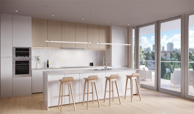 kitchen with oven, plenty of natural light, and light hardwood / wood-style flooring