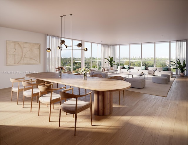 dining area featuring light hardwood / wood-style floors, a chandelier, and a wall of windows