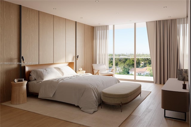 bedroom with a wall of windows and light hardwood / wood-style floors