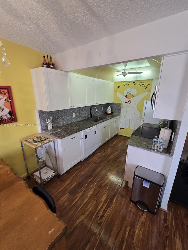 kitchen with sink, dark hardwood / wood-style floors, dark stone counters, decorative backsplash, and white cabinets