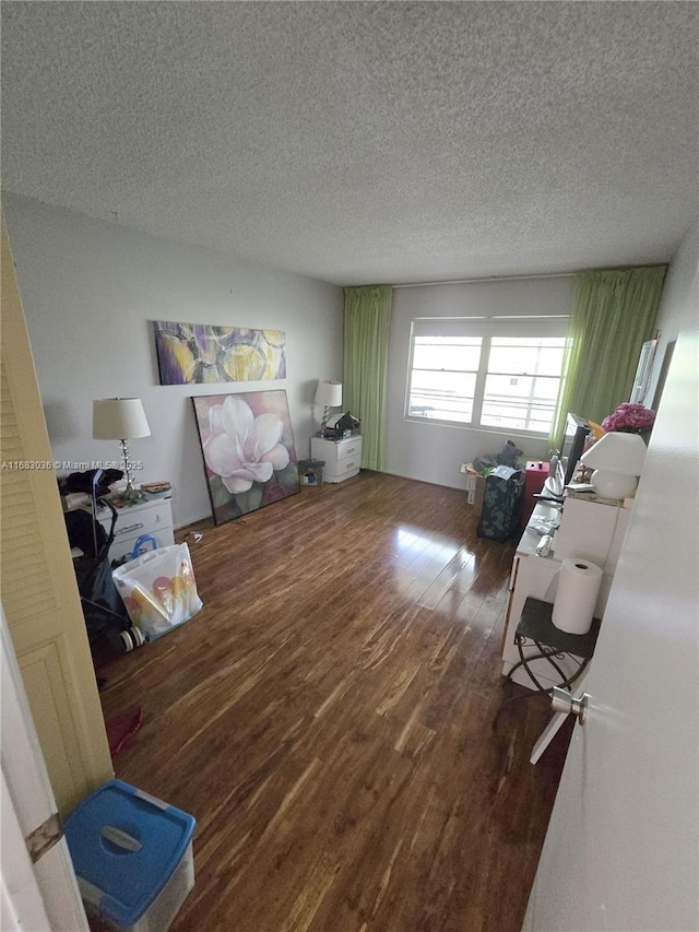 living room with a textured ceiling and dark hardwood / wood-style flooring