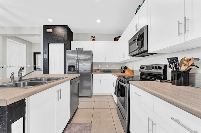 kitchen with stainless steel appliances, white cabinetry, and sink