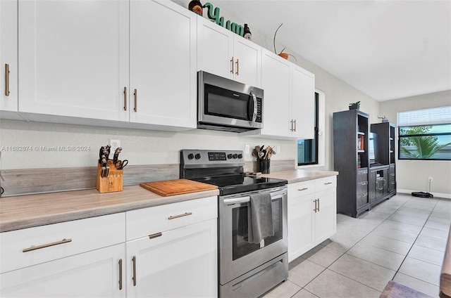 kitchen featuring white cabinetry, stainless steel appliances, and light tile patterned floors