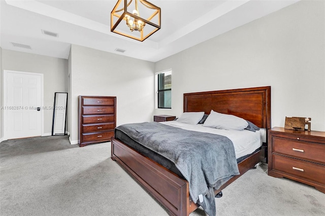 bedroom featuring an inviting chandelier and light colored carpet