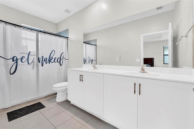 bathroom featuring toilet, vanity, tile patterned floors, and walk in shower