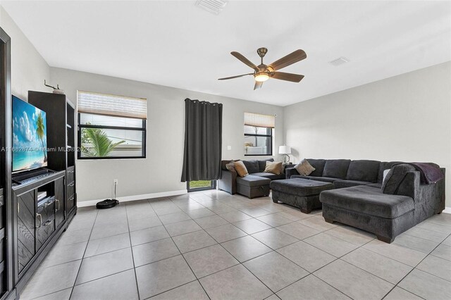 tiled living room with a wealth of natural light and ceiling fan