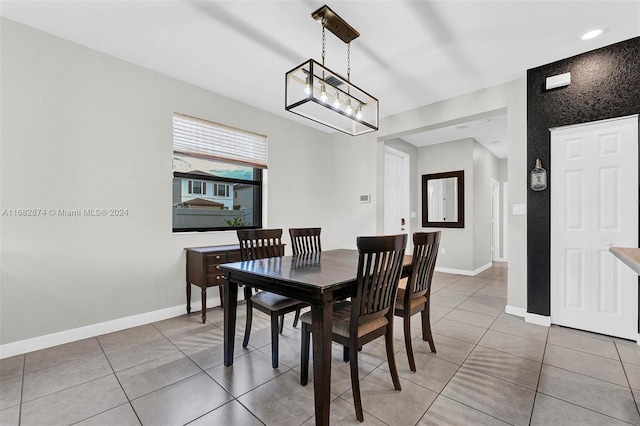 tiled dining room featuring a chandelier