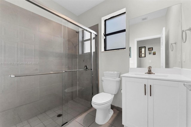 bathroom with tile patterned flooring, vanity, toilet, and a shower with shower door