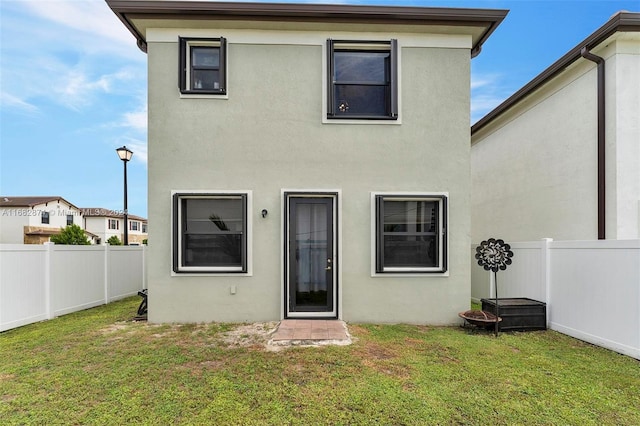 rear view of property featuring a yard