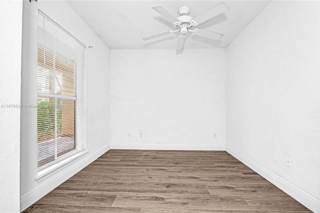 empty room with a ceiling fan, baseboards, and wood finished floors