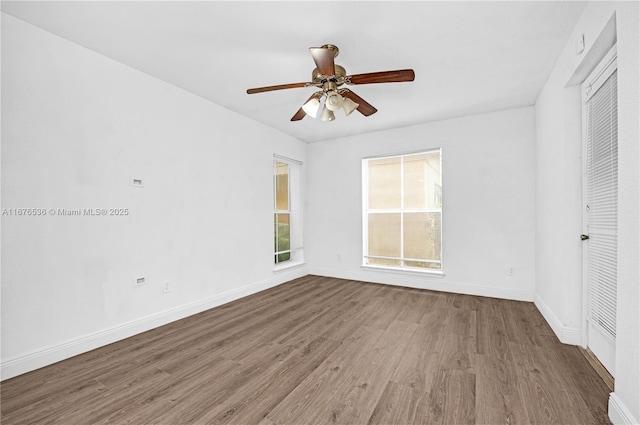 interior space with baseboards, a ceiling fan, and wood finished floors