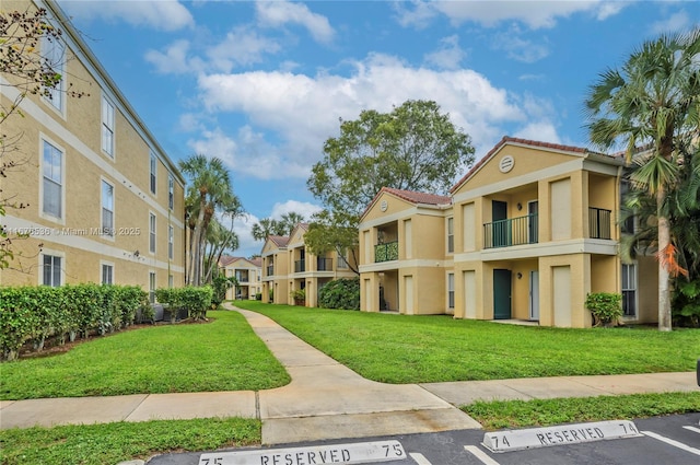 view of property's community with a lawn, uncovered parking, and a residential view