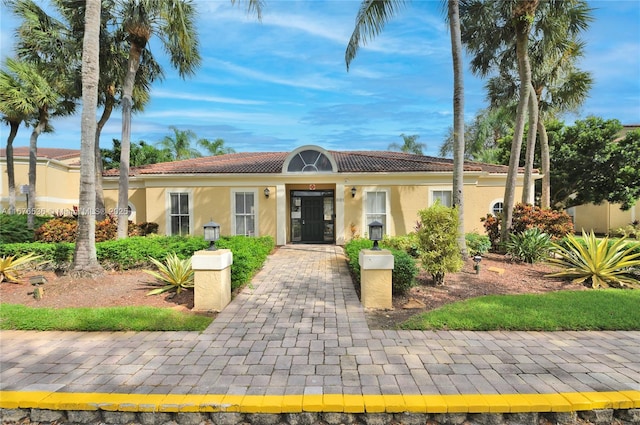 view of front of home featuring stucco siding and a tile roof
