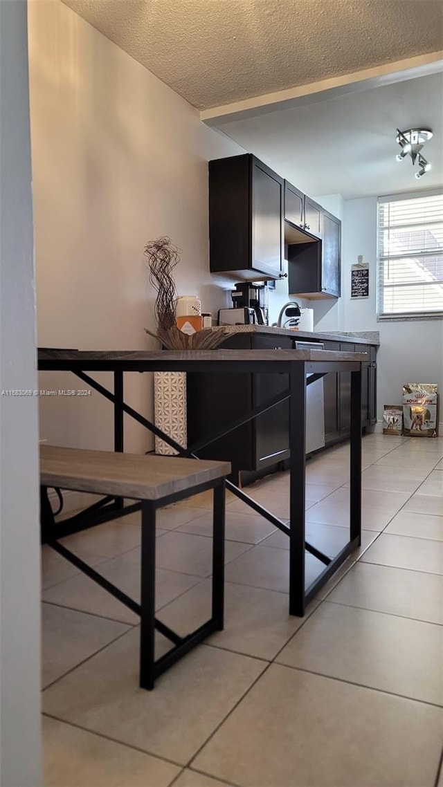 kitchen featuring a textured ceiling and light tile patterned floors