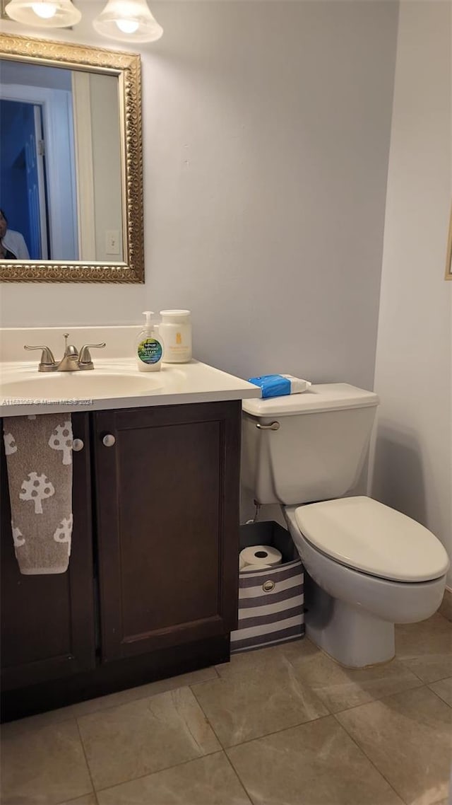 bathroom with vanity, toilet, and tile patterned flooring