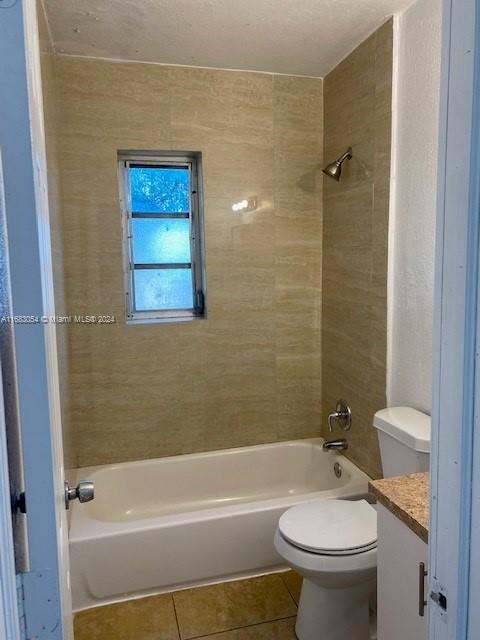 full bathroom with vanity, toilet, tile patterned floors, and tiled shower / bath