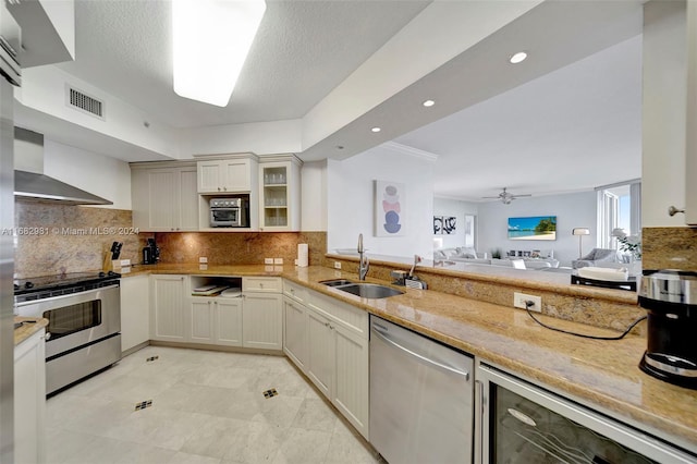 kitchen with wine cooler, stainless steel appliances, wall chimney exhaust hood, and backsplash