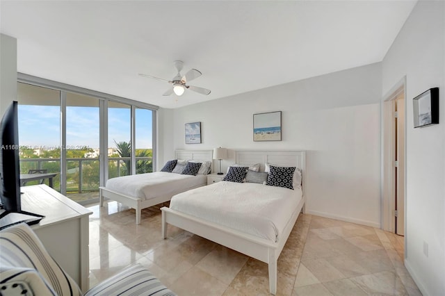 bedroom with expansive windows and ceiling fan