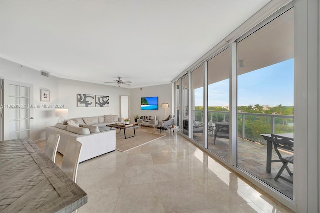 living room featuring ceiling fan and a wall of windows