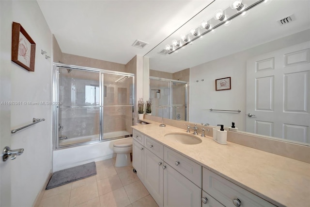 full bathroom featuring vanity, toilet, tile patterned floors, and enclosed tub / shower combo