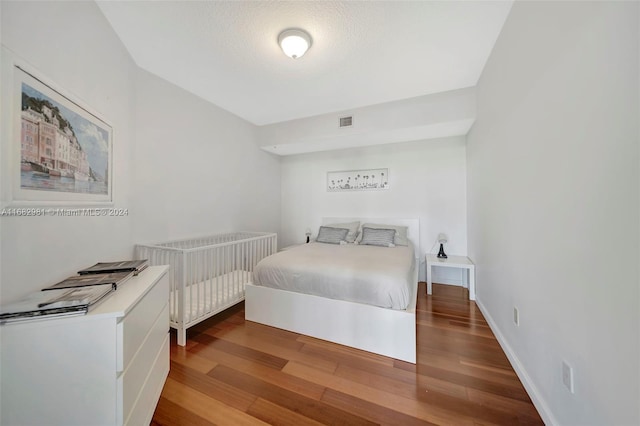 bedroom featuring a textured ceiling and wood-type flooring