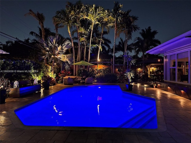 pool at twilight with a patio