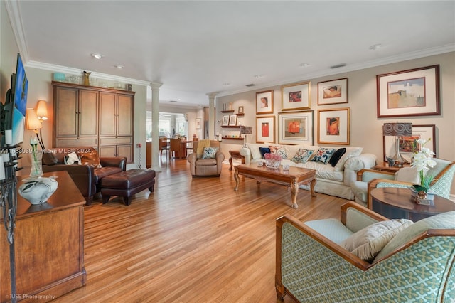 living room with light hardwood / wood-style floors, crown molding, and decorative columns