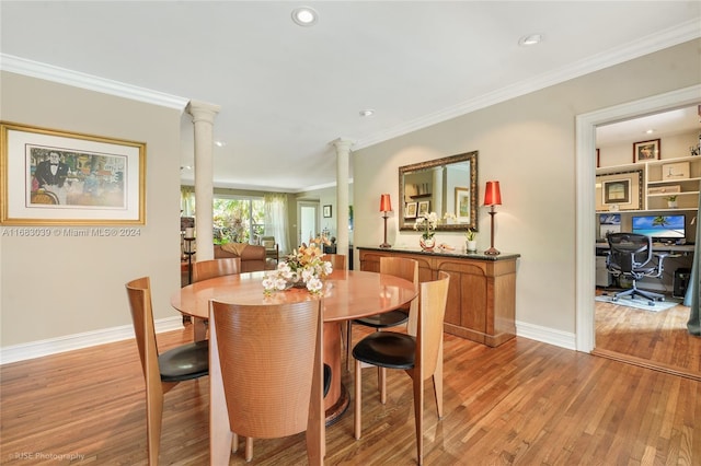 dining space with ornate columns, light hardwood / wood-style flooring, and crown molding