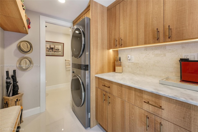 clothes washing area featuring stacked washer / drying machine