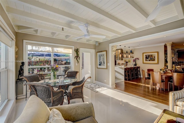 dining space with ceiling fan, beamed ceiling, and light hardwood / wood-style flooring