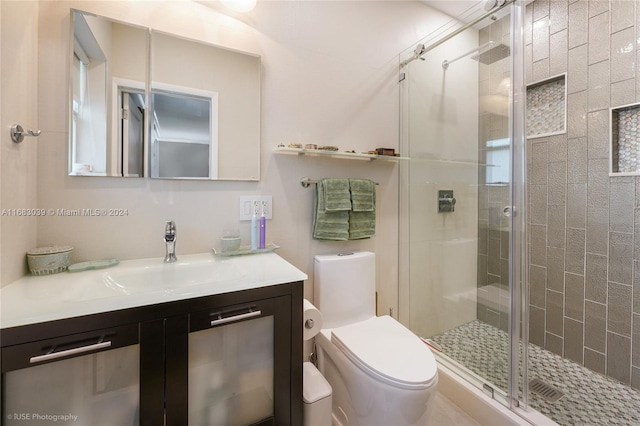 bathroom with toilet, vanity, and an enclosed shower