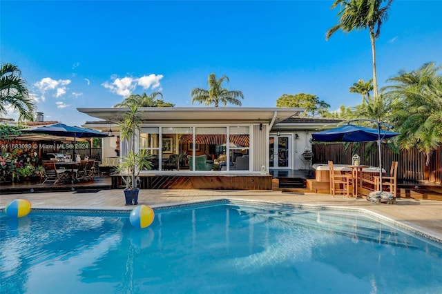 view of pool with a wooden deck and a patio