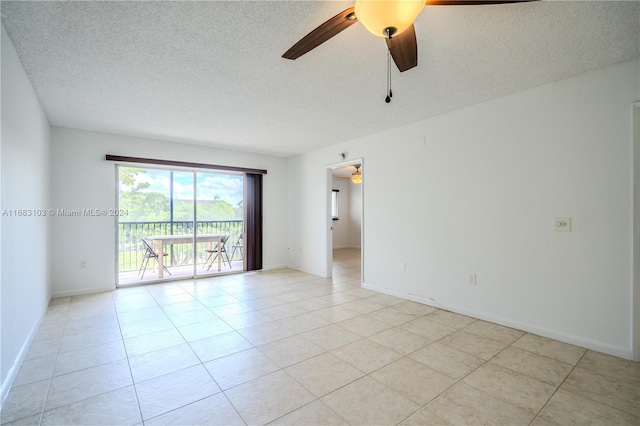 tiled empty room with a textured ceiling and ceiling fan