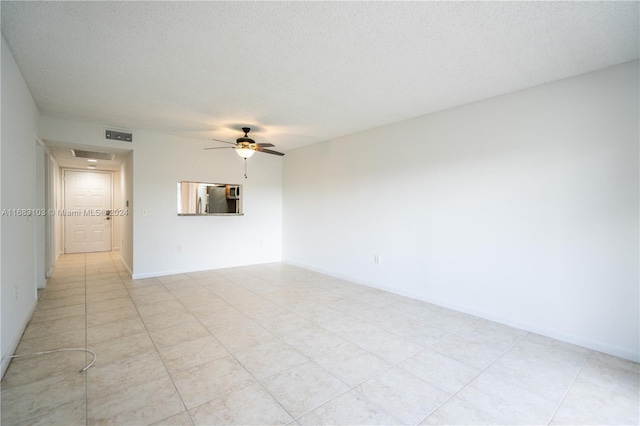 empty room with a textured ceiling and ceiling fan