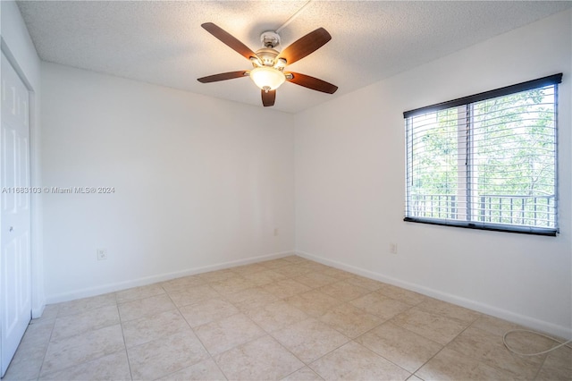 spare room with ceiling fan and a textured ceiling