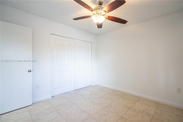 unfurnished bedroom featuring a closet, ceiling fan, and a textured ceiling