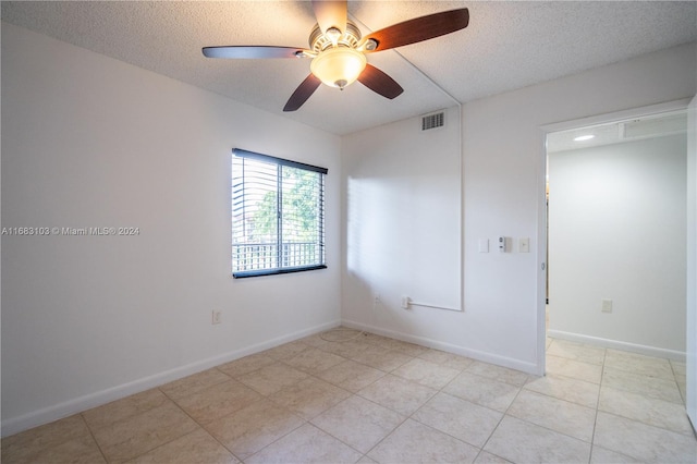 unfurnished room with a textured ceiling, light tile patterned floors, and ceiling fan