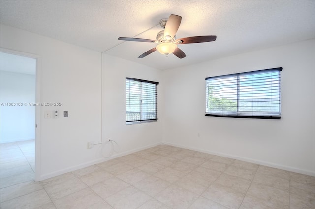 spare room featuring ceiling fan, a textured ceiling, and plenty of natural light