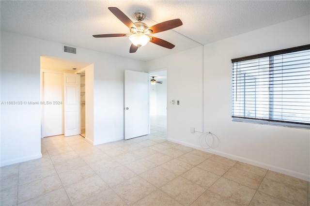 empty room featuring a textured ceiling and ceiling fan