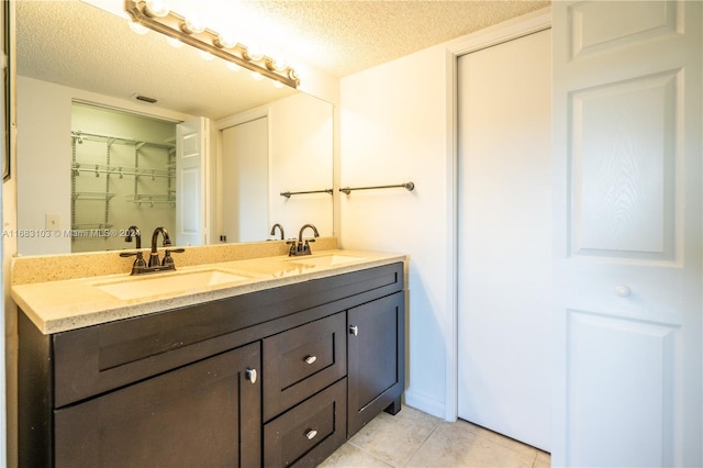 bathroom featuring vanity, a textured ceiling, and tile patterned flooring