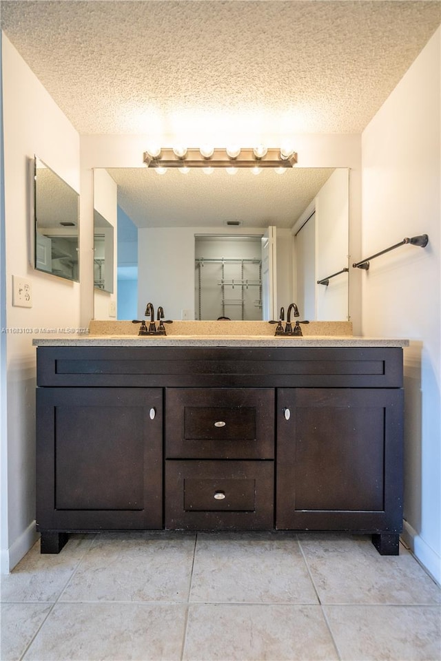 bathroom with vanity, tile patterned floors, and a textured ceiling