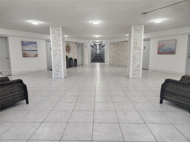 basement featuring a textured ceiling and light tile patterned floors