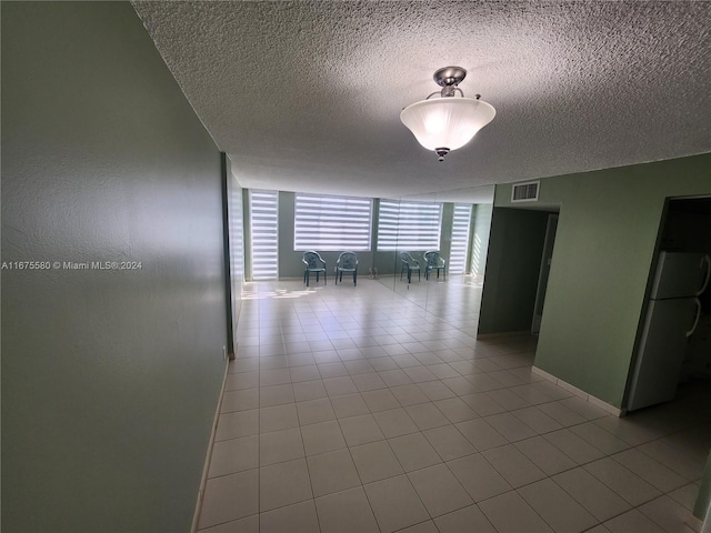 spare room featuring a textured ceiling and light tile patterned floors