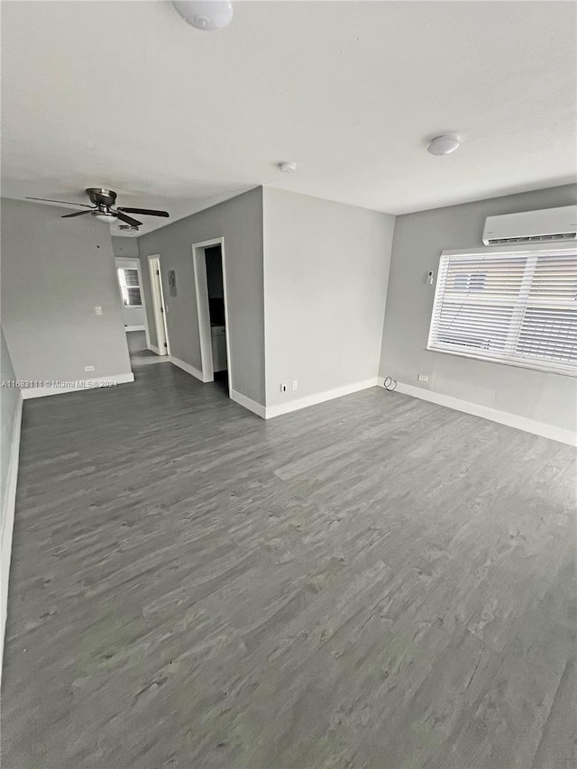 unfurnished living room with a wall unit AC, dark hardwood / wood-style floors, and ceiling fan