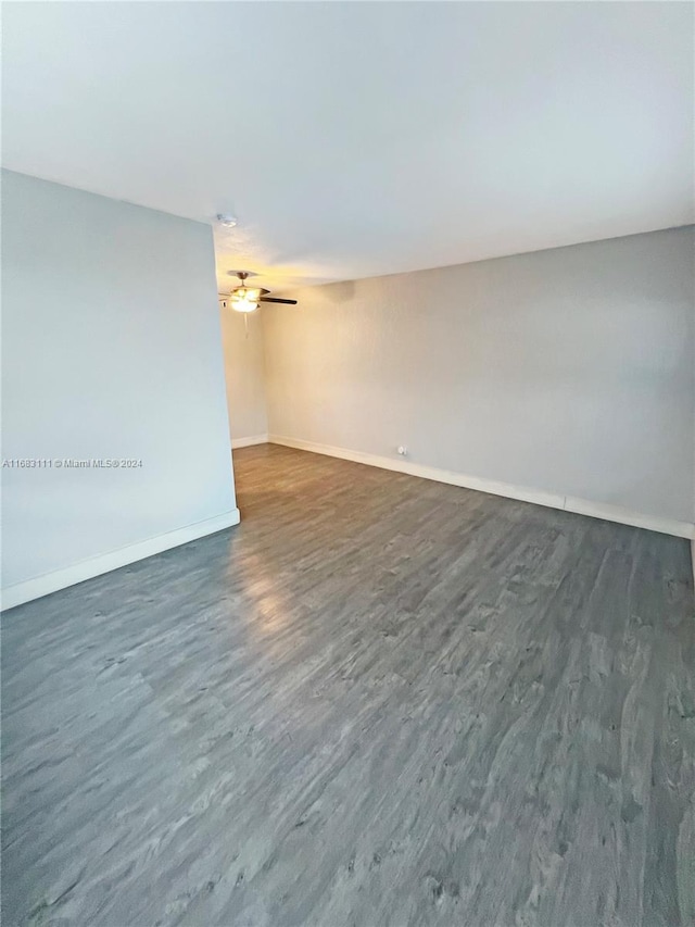 empty room featuring ceiling fan and dark hardwood / wood-style floors