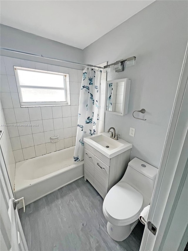 full bathroom with vanity, toilet, shower / bath combo with shower curtain, and wood-type flooring